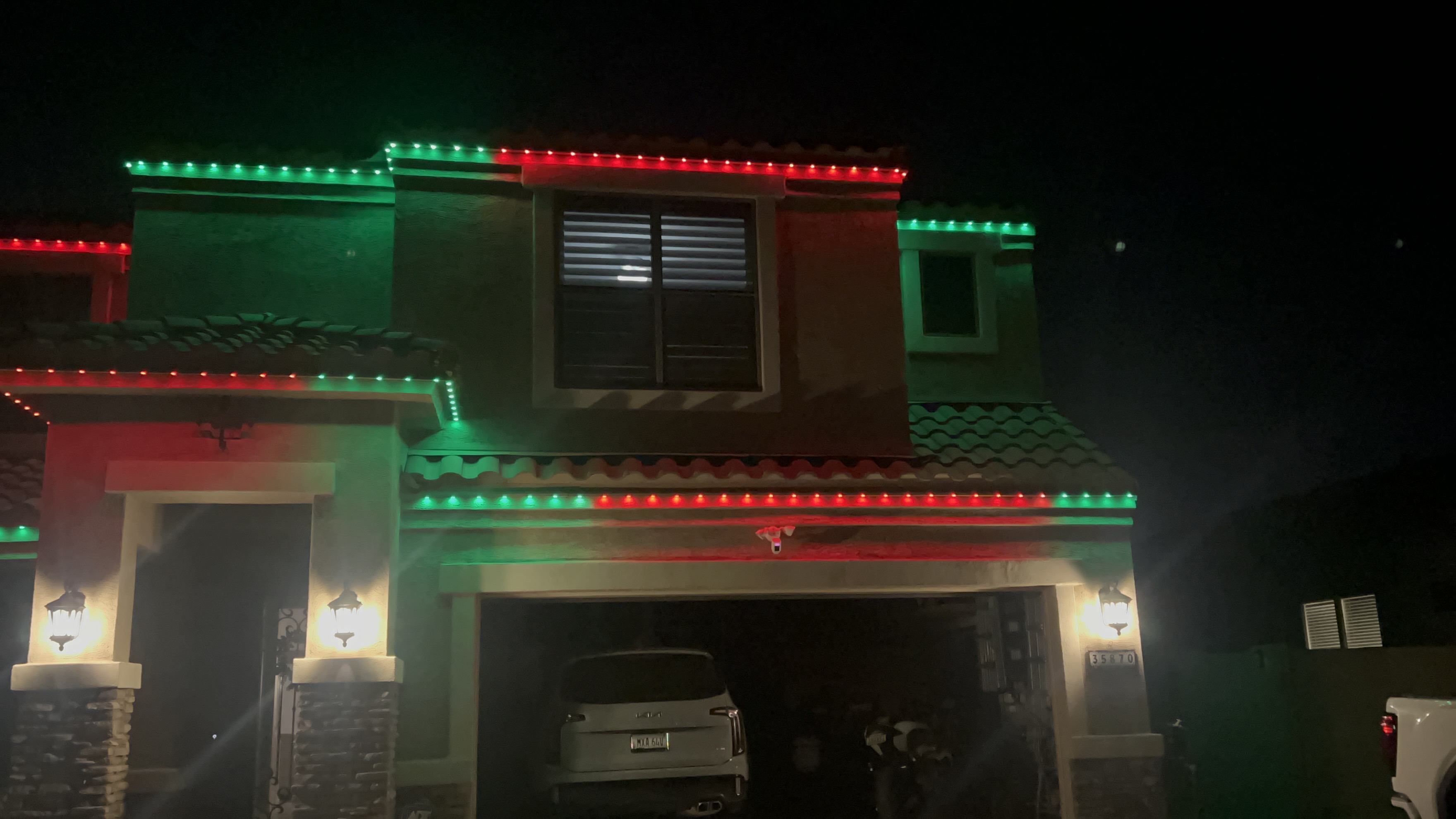 Warm amber LED roofline lighting on Papillion home at night